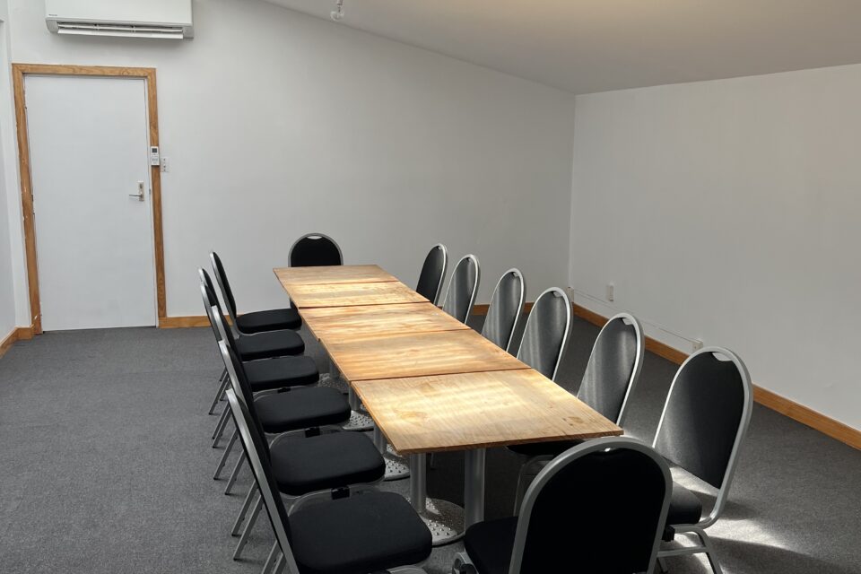 Backroom with boardroom style table and chairs set up.